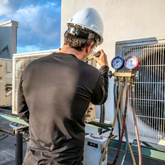 AC repair man making adjustments to a small business system